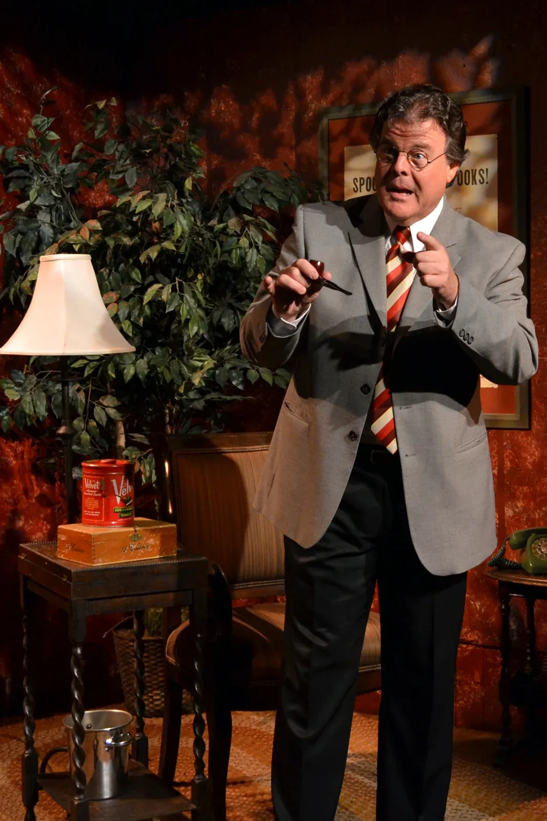 John in character with round glasses and a pipe